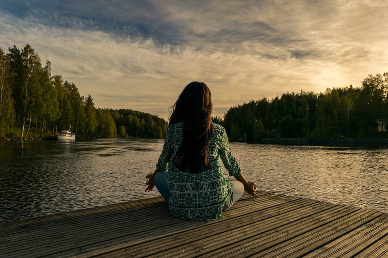Woman practicing yoga at sunset
